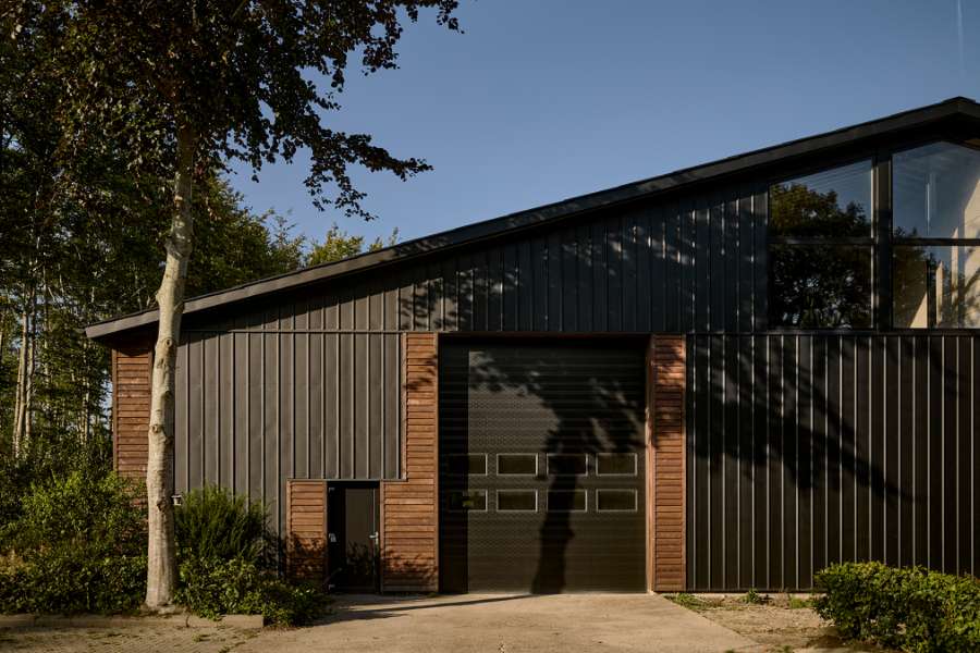 Sommerlys sænker sig over stålprofiler i skoven, Klæstruplundvej 11, 9240 Nibe